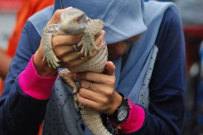 Woman holding iguana