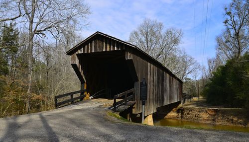 Covered footbridge over river against sky