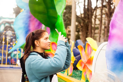 Teenage girl photographing at traveling carnival
