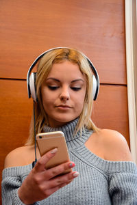 Woman listening music while sitting at cafe