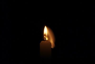 Close-up of illuminated candle against black background