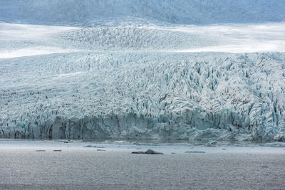 Sea against snowy landscape during winter