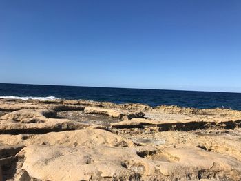 Scenic view of sea against clear blue sky