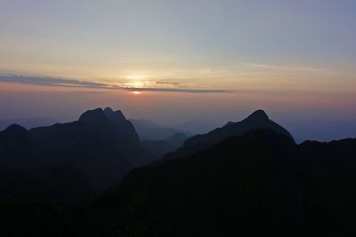 Scenic view of silhouette mountains against sky at sunset