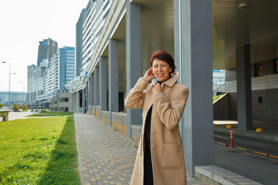 Young man using mobile phone in city