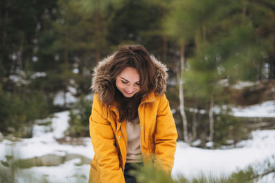 Portrait of smiling woman standing in snow