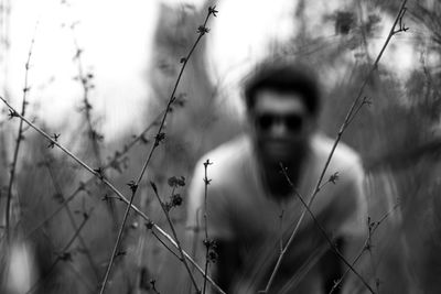 Portrait of man on field seen through fence