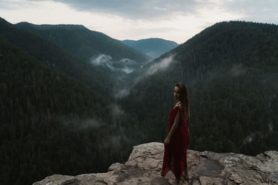 Rear view of woman standing on rock