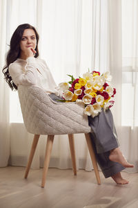 Portrait of young woman sitting on sofa at home