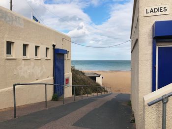 Built structure on beach by sea against sky