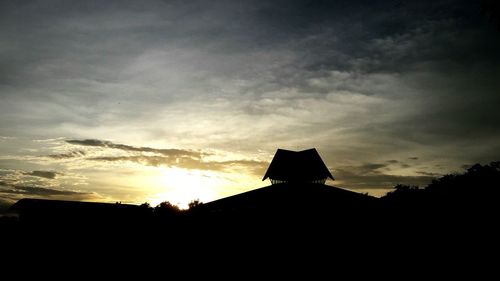 Low angle view of buildings against cloudy sky