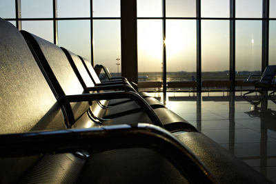 Empty chairs at airport against sky