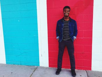 Portrait of young man leaning against wall