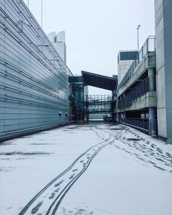 Railroad track in city against clear sky during winter