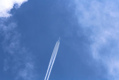 Low angle view of airplane flying against blue sky