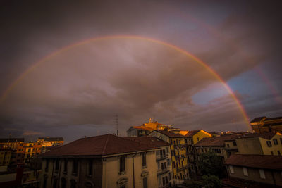 Rainbow over city against sky