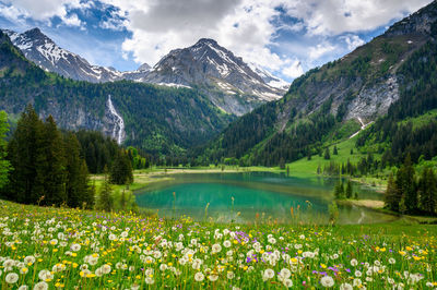 Scenic view of lake by mountains against sky