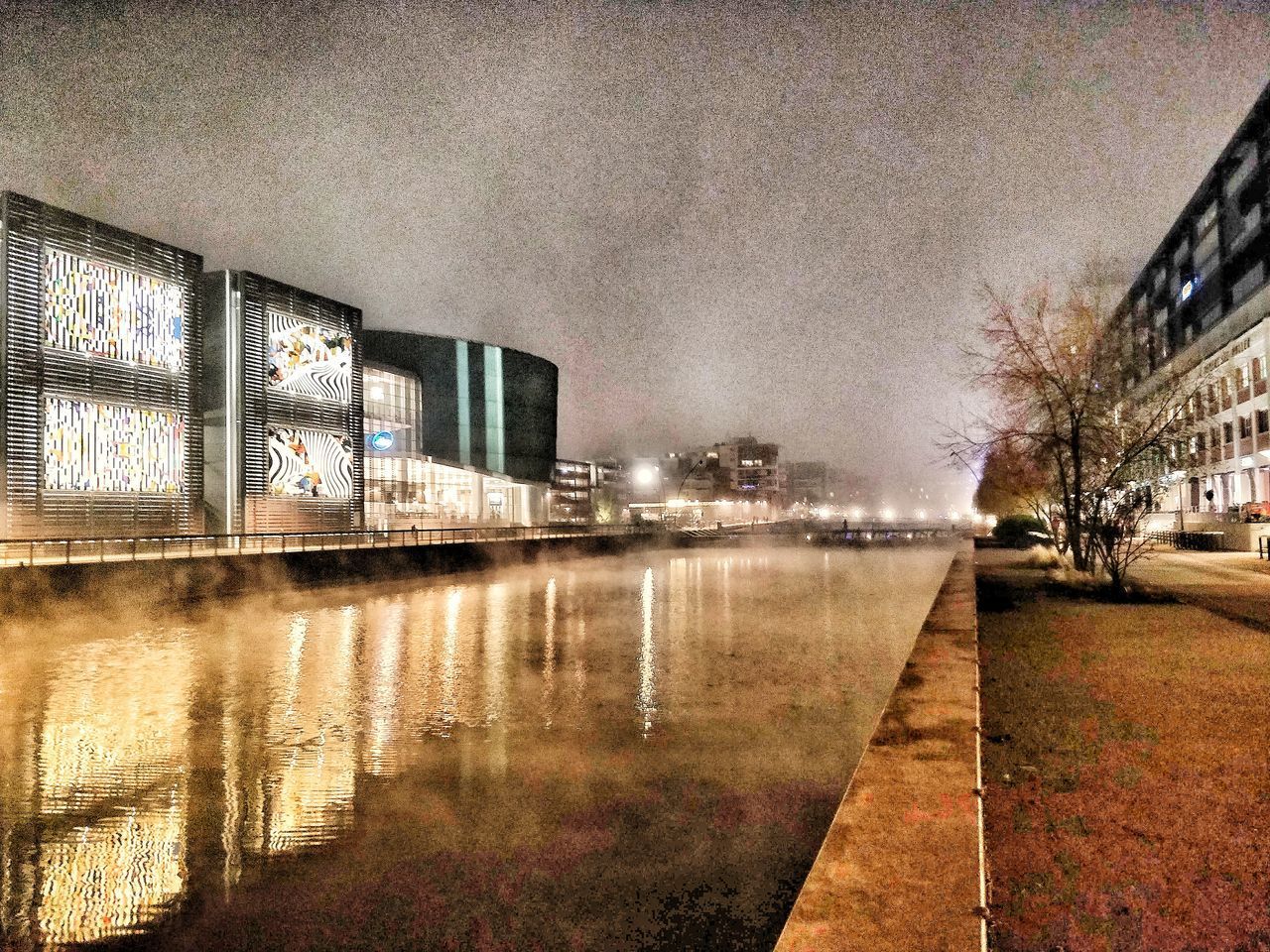 REFLECTION OF ILLUMINATED BUILDING IN WATER