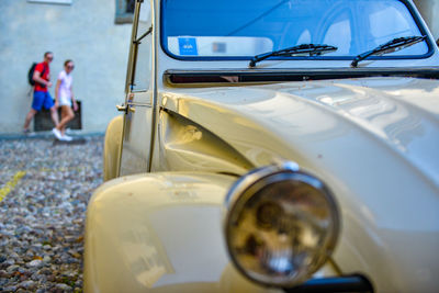 Close-up of vintage car with people in background