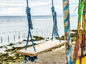 Rope tied to wooden post on beach