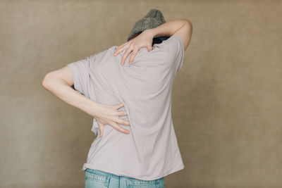 Midsection of woman standing against wall