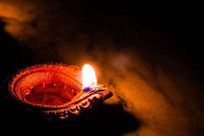 Close-up of lit candle in the dark