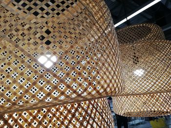 Low angle view of illuminated lamp hanging on ceiling in building