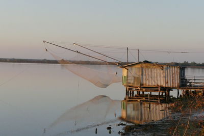 Fishing net in lake against clear sky