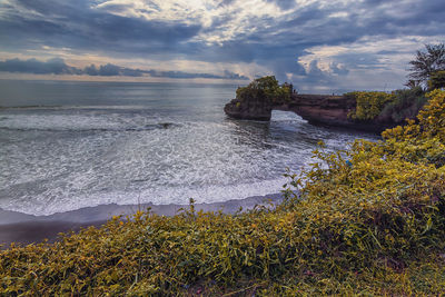 Beautiful landscape view of a beach and pura batu bolong temple as the background