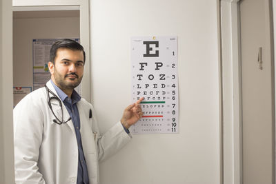 Portrait of man standing in front of open door