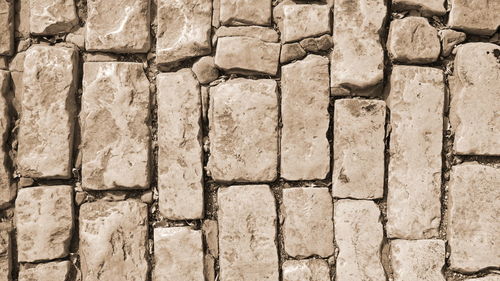 Sepia stone wall background. ancient rustic shabby antique brickwork facade with old damaged