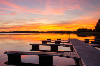 Pier over lake against sky during sunset