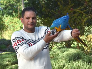 Portrait of a smiling young man holding bird