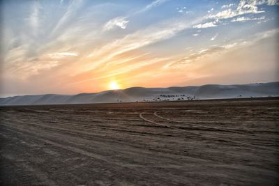 Scenic view of desert against sky during sunset