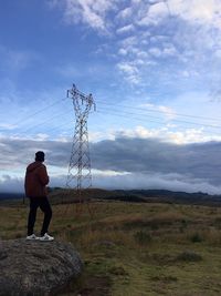 Man standing on rock field against sky