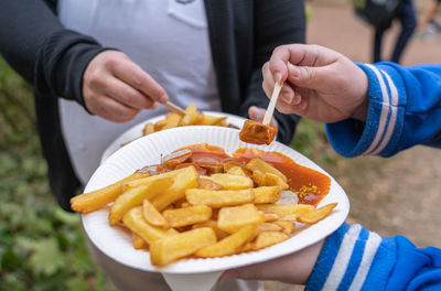 Paper plate with traditional german currywurst and french fries