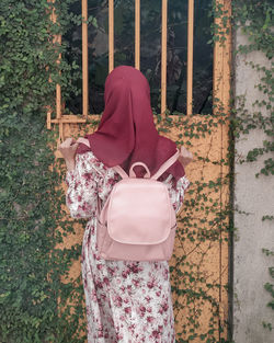 Rear view of girl standing against plants