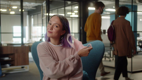 Portrait of young woman sitting in gym