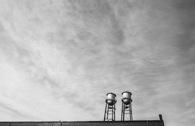 Low angle view of water tanks on building against sky