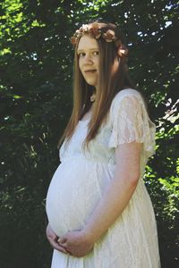 Portrait of beautiful woman standing against tree