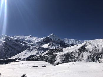 Scenic view of snowcapped mountains against clear sky