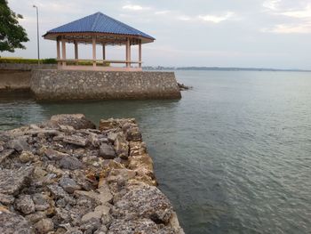 Gazebo by sea against sky