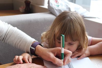 Man teaching girl at home