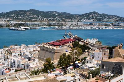Cityscape by sea against sky