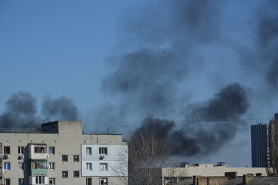 There is black smoke from a rocket or bomb explosion in a city during a war