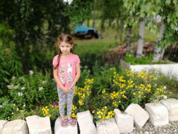 Portrait of a smiling girl standing against plants