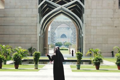 Rear view of woman in burka standing in front of tuanku mizan zainal abidin mosque