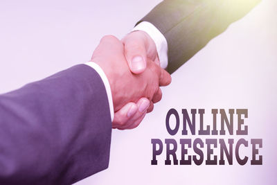 Close-up of hand holding text against white background