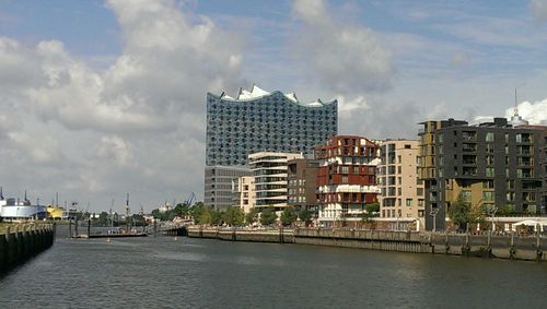 Buildings in city against cloudy sky