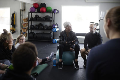 Smiling people talking together in gym